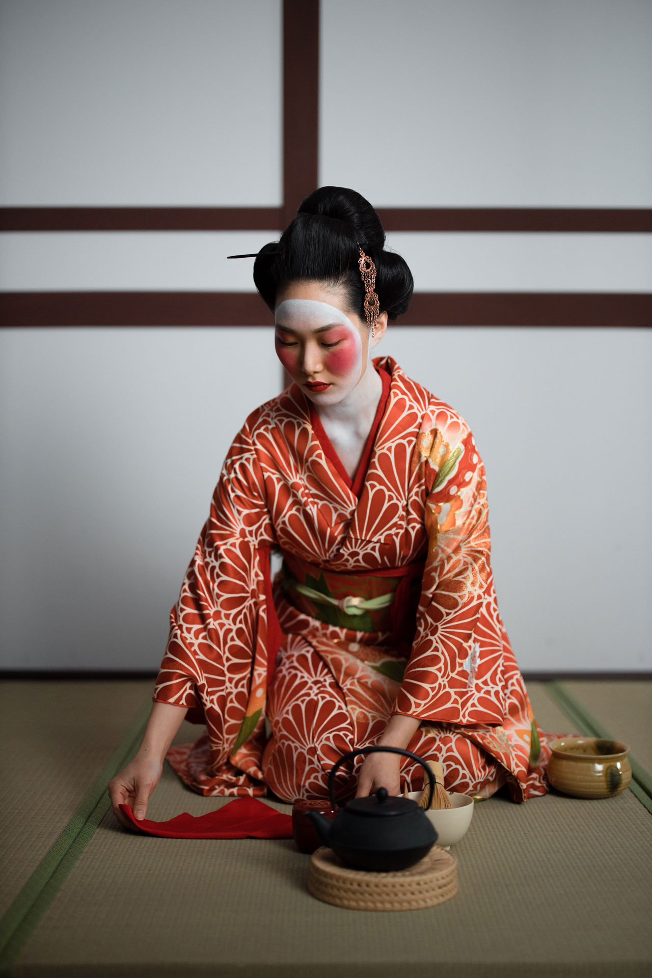 Geisha sentada después de aplicarse Maquillaje japonés antes de una reunión importante
